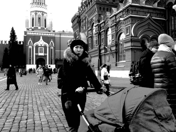 Moscow, Russia - February 24, 2020: Young asian woman is pushing a baby stroller on Red Square