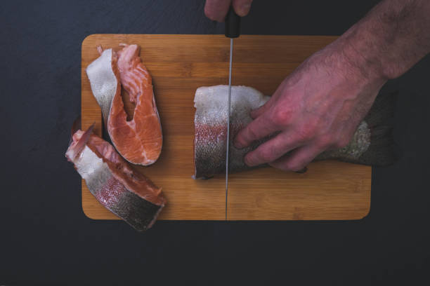 istock salmon cut on a wooden board on black stone 1208628855