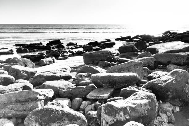 The beach at Taghazout, a tourist area in Morocco that is receiving considerable investment in new hotels, apartments etc. In the foreground are rocks near the town itself.