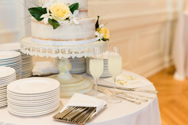 istock Wedding Reception Details - Wedding Cake, Champagne Flutes, White Plates and Silverware 1208632180