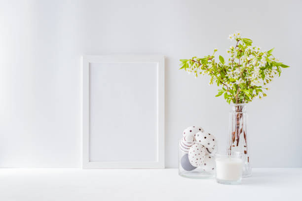 istock Home interior with easter decor. Mockup with a white frame and spring flowers in a vases on a light background 1208633881