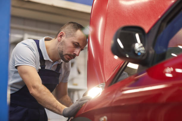 istock Mechanic Looking at Car in Auto Shop 1208634454
