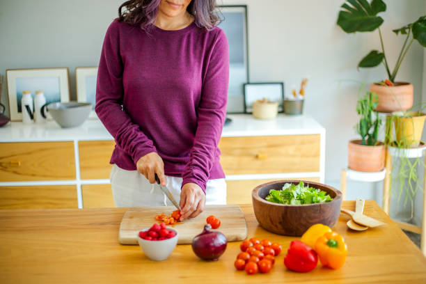 istock Woman making salad at home 1208634725