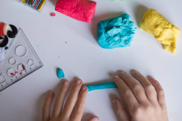 mani per bambini che fanno figura giocattolo con argilla modellante o plastilina - shaping clay foto e immagini stock