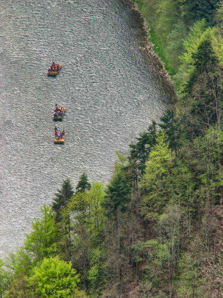 Beklenischevo, Russia - June 12, 2005: Four water tourists move on rapid river. The girl fell in water