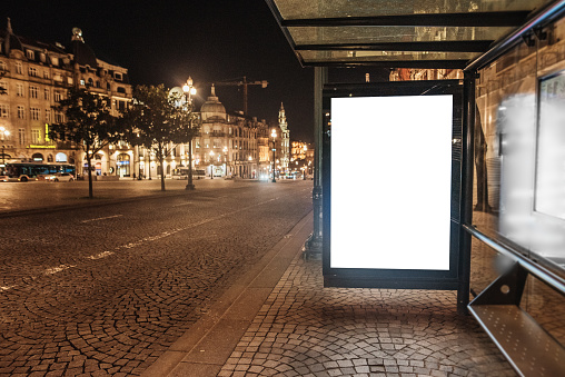 Bus stop with blank billboard at night