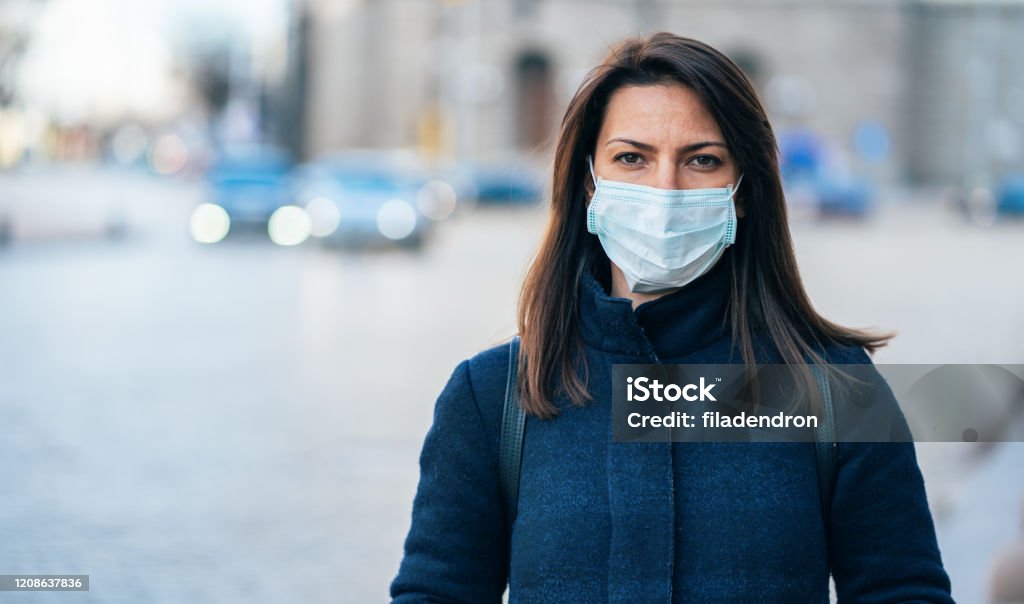 Woman with face protective mask Portrait of young woman on the street wearing  face protective mask to prevent Coronavirus and anti-smog Protective Face Mask Stock Photo