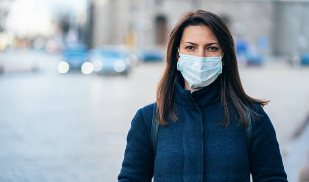 Woman with face protective mask Portrait of young woman on the street wearing  face protective mask to prevent Coronavirus and anti-smog protective mask workwear stock pictures, royalty-free photos & images