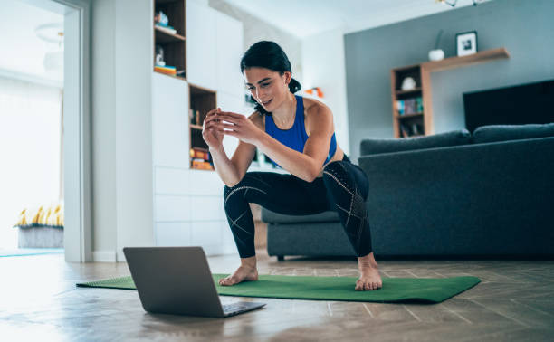 woman working out at home - concentration flexibility full length healthy lifestyle imagens e fotografias de stock