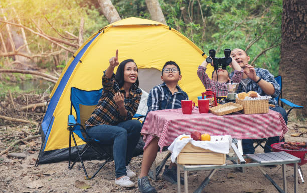 Happy Family Asian Enjoying picnic and Camping Holiday In Countryside Happy Family Asian Enjoying holiday picnic and Camping and looking bird with binocular spyglass In Countryside. people travel outdoors concept. family camping stock pictures, royalty-free photos & images