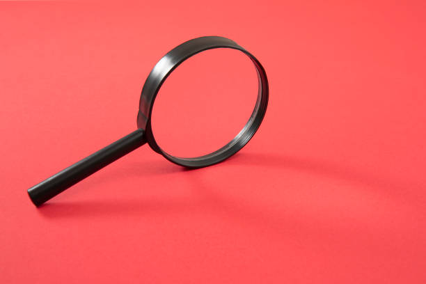 istock Magnifying Glass on Red Background 1208639279