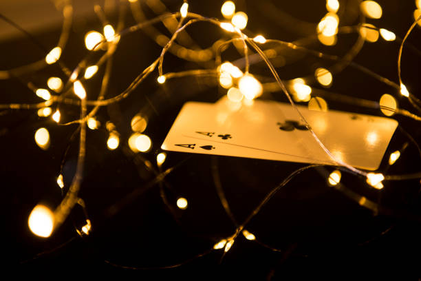 Two black aces cards in blur Christmas lights. Two black aces cards in blur Christmas lights. christmas casino stock pictures, royalty-free photos & images