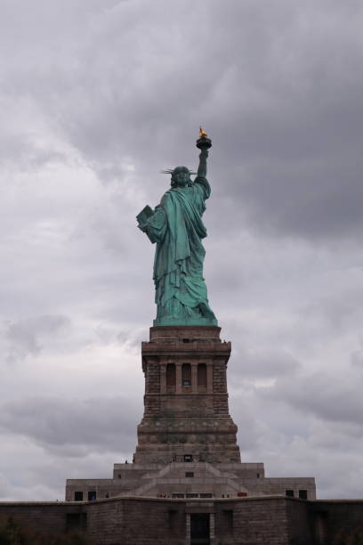 istock Statue of liberty from rear with cloudy sky 1208641863