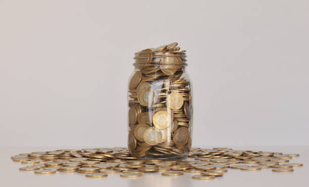 Glass Jar full of Mexican coins Glass Bottle full of Mexican coins mexican currency stock pictures, royalty-free photos & images