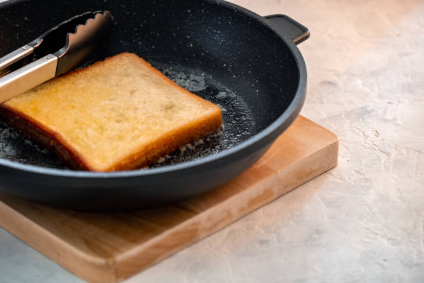 Crispy white bread toasters with butter on a wooden board on a gray background