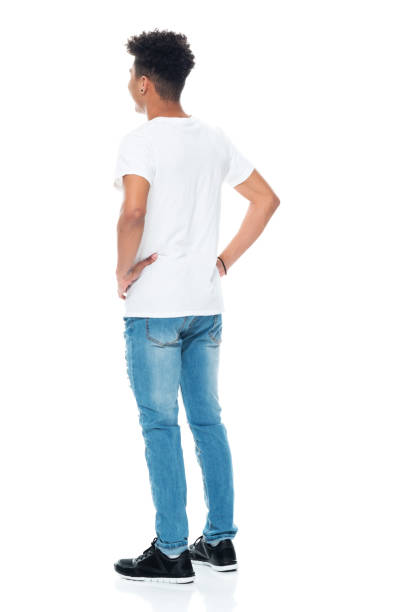 African ethnicity boys standing in front of white background wearing t-shirt Full length of aged 18-19 years old with curly hair african ethnicity boys standing in front of white background wearing t-shirt with hand on hip ass boy stock pictures, royalty-free photos & images
