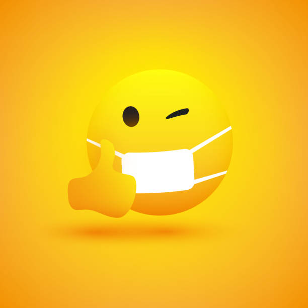istock Emoticon with Winking Eye, Showing Thumbs Up and Wearing Medical Mask 1208646306