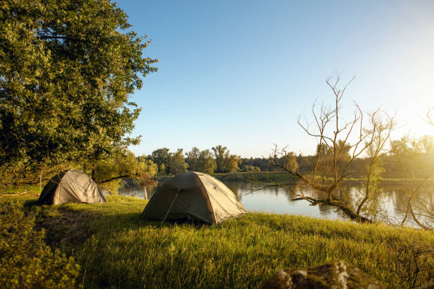 istock Two tents next to a river in the morning 1208647748