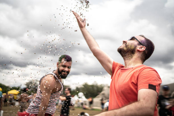 istock Friends having fun blowing confetti at carnival party 1208647952