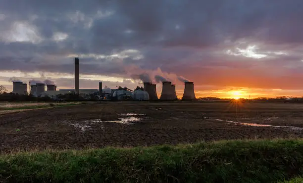 Photo of Drax, a rural village in North Yorkshire with the sun just about to rise in the east and plumes of water vapour emitting from the Cooling towers of a local power station.