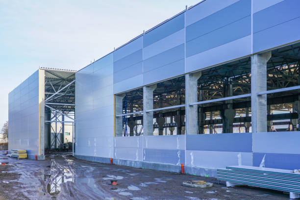wall assembly of a new factory building using steel sandwich panels wall assembly of a new modern factory building using steel sandwich panels sandwich panel photos stock pictures, royalty-free photos & images