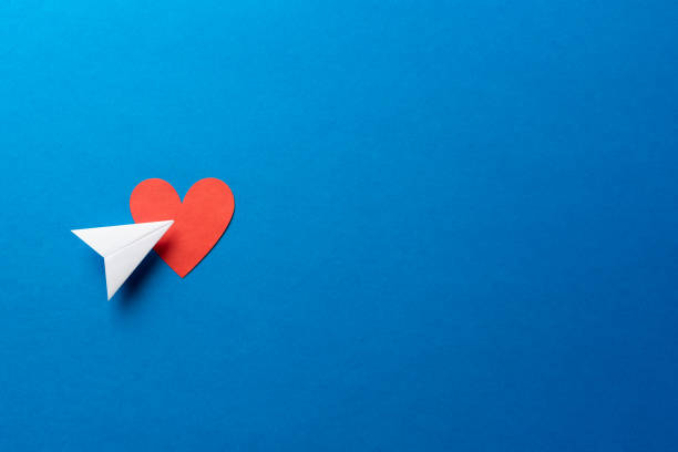 Paper airplane with red heart shape on blue background with space for text. Sharing and send symbol concept. Airplane flight transport sign. Landing page concept. Paper airplane with red heart shape on blue background with space for text. Sharing and send symbol concept. Airplane flight transport sign. Landing page concept. landing page photos stock pictures, royalty-free photos & images