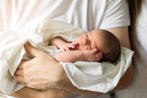 father holds naked newborn son in his hands in a white diaper. - newborn human hand baby father imagens e fotografias de stock