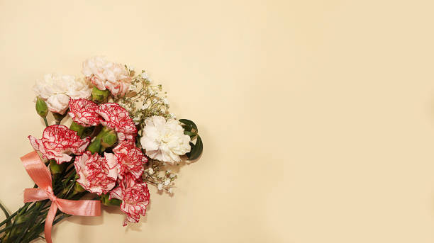 istock Carnations on a yellow table, abstract spring floral background. Creative modern bouquet, minimal holiday concept. Greeting card for Women's Day or Mother's Day, happy birthday, wedding, gift for loved ones, place for text, banner for screen, 1208652967