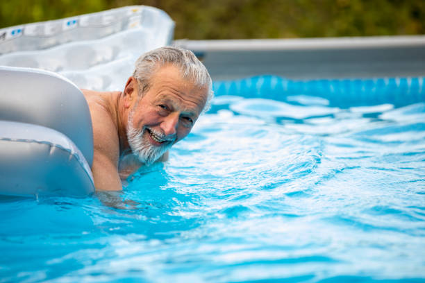 istock Happy healthy elder enjoy fun with airbed at swimming pool 1208652990