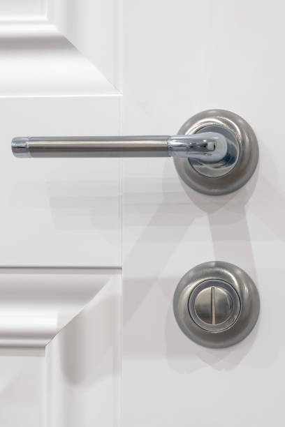 istock Metal handle with a rotary lock on a white door, close-up 1208653245