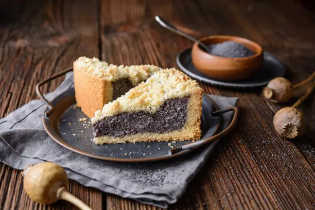 Mohnkuchen, German poppy seed cake topped with crunchy streusel on rustic wooden background