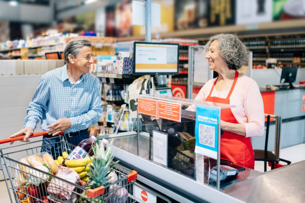 istock Senior man paying at supermarket cashier 1208657708