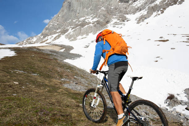 istock Mountain biker ascends steep mountainside view of the Eiger behind 1208658445