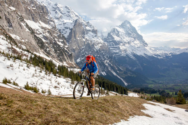 el ciclista de montaña asciende con una vista empinada de la ladera de la montaña del eiger detrás - eiger switzerland mountain sport fotografías e imágenes de stock