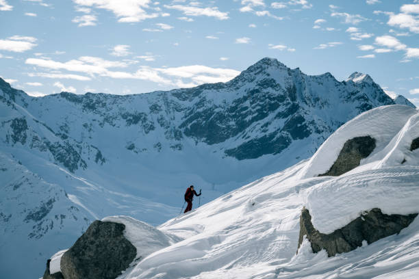 istock Ski mountaineer ascends snowy mountain ridge line 1208658505