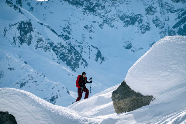 istock Ski mountaineer ascends snowy mountain ridge line 1208659021