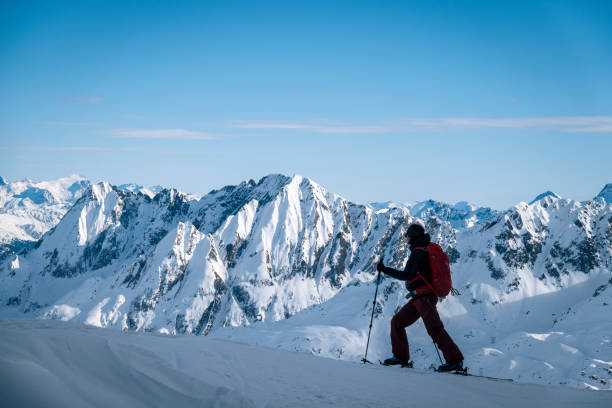istock Ski mountaineer ascends snowy mountain ridge line 1208659058
