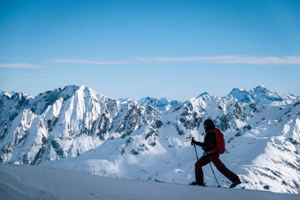 istock Ski mountaineer ascends snowy mountain ridge line 1208659097