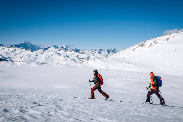 istock Ski mountaineers ascend snowy mountain ridge line 1208659119