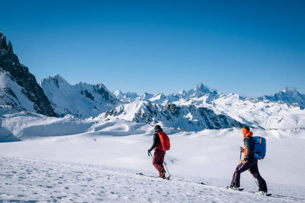 istock Ski mountaineers ascend snowy mountain ridge line 1208659148