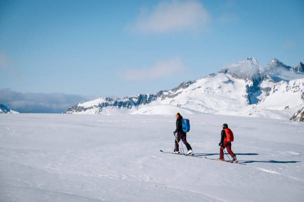 istock Ski mountaineers ascend snowy mountain ridge line 1208659242
