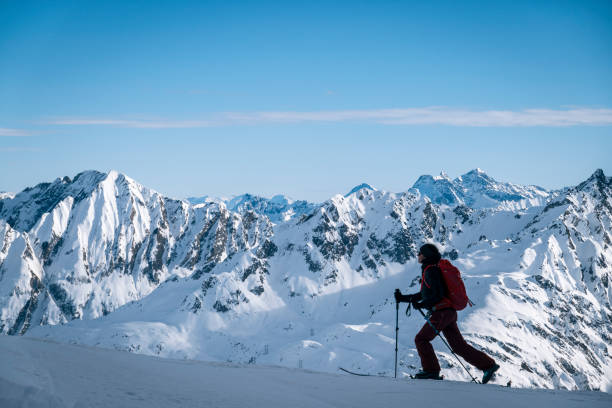 istock Ski mountaineer ascends snowy mountain ridge line 1208659243