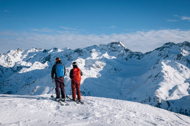 istock Ski mountaineers ascend snowy mountain ridge line 1208659492
