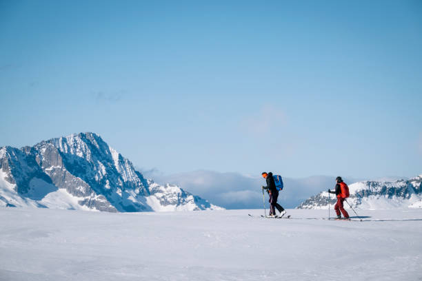 istock Ski mountaineers ascend snowy mountain ridge line 1208659567