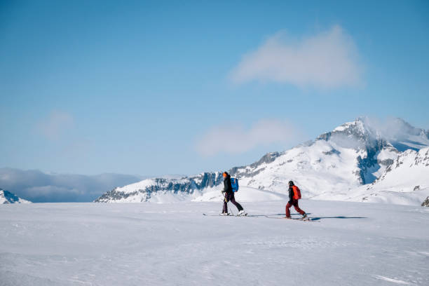 istock Ski mountaineers ascend snowy mountain ridge line 1208659604