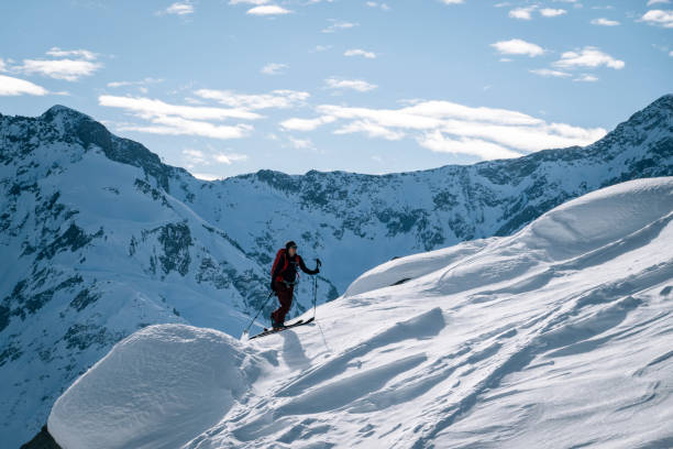 istock Ski mountaineer ascends snowy mountain ridge line 1208659633