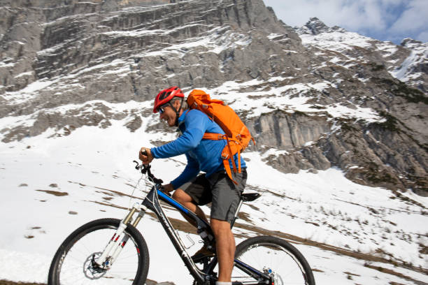 istock Mountain biker ascends steep mountainside view of the Eiger behind 1208659675