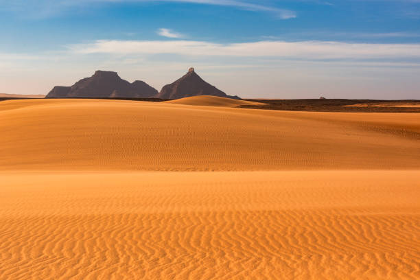 Dunes and mountains in the remote Ennedi Mountains (massif) in the Sahara desert, North-East Chad. The Ennedi massif was declared as an UNESCO World Heritage site in 2016.