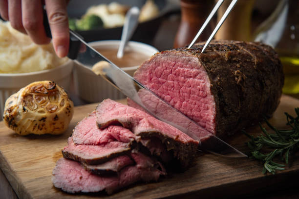 istock sliceing roasted eye of round beef with knife 1208663775