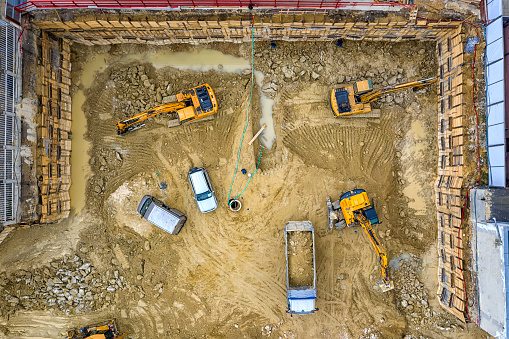 Heavy construction equipment working at the construction site. Aerial view from drone